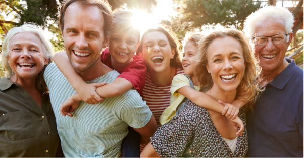 Family picture, husband, wife, young boy and girl smiling while walking in the park